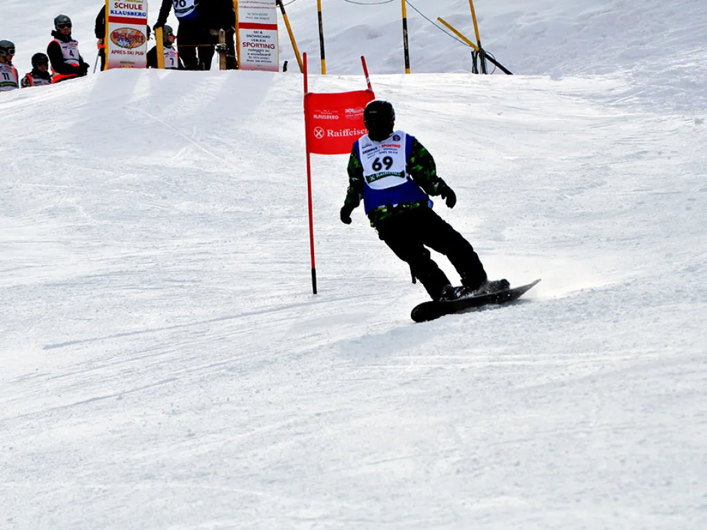 Snowboarder mit Startnummer 69 am roten Tor.